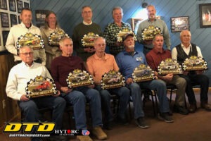 Men displaying racing awards