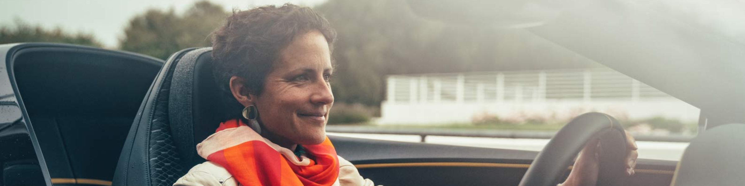 Woman wearing orange scarf driving car