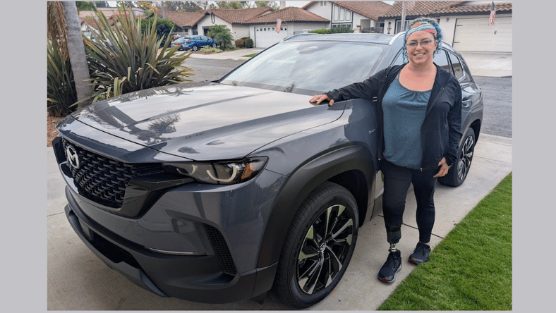 woman beside black car in driveway