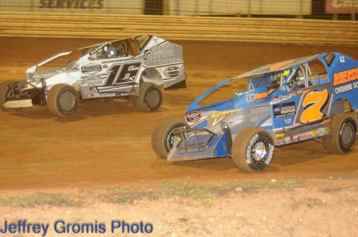 Two sprint cars racing on dirt