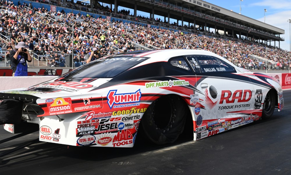 Race car speeding past grandstand crowd