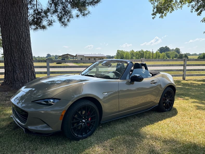 Silver Mazda Miata parked on grass