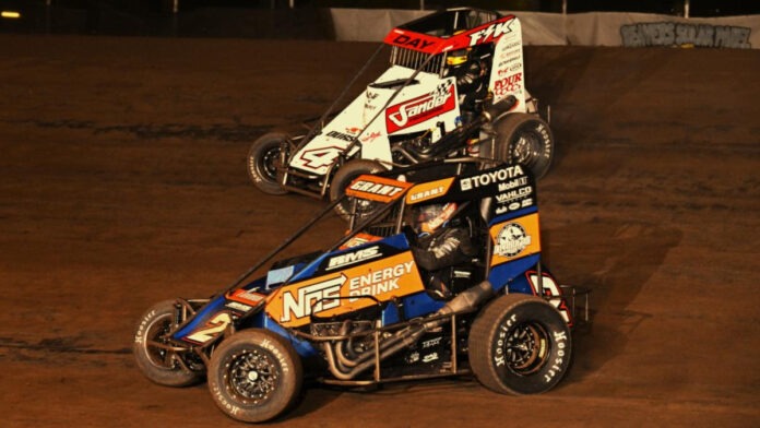 Three sprint cars racing dirt track