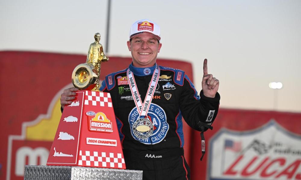 Racing driver celebrating with trophy