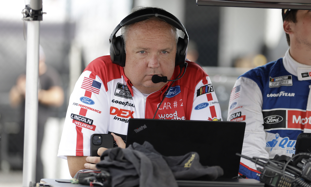 Race engineer wearing headset at laptop