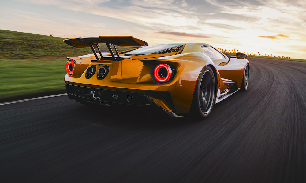 Yellow sports car on sunset road