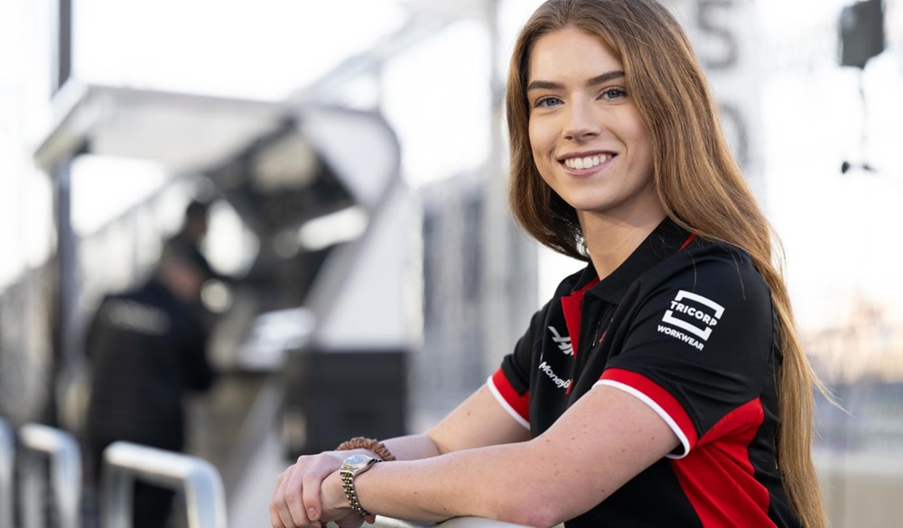 Smiling female racer in uniform