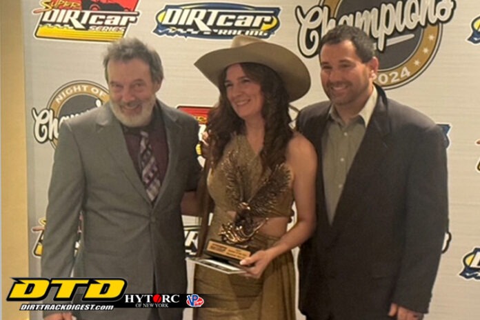 Three racers holding victory trophy