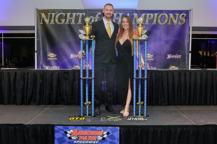 Man and woman celebrate with trophies