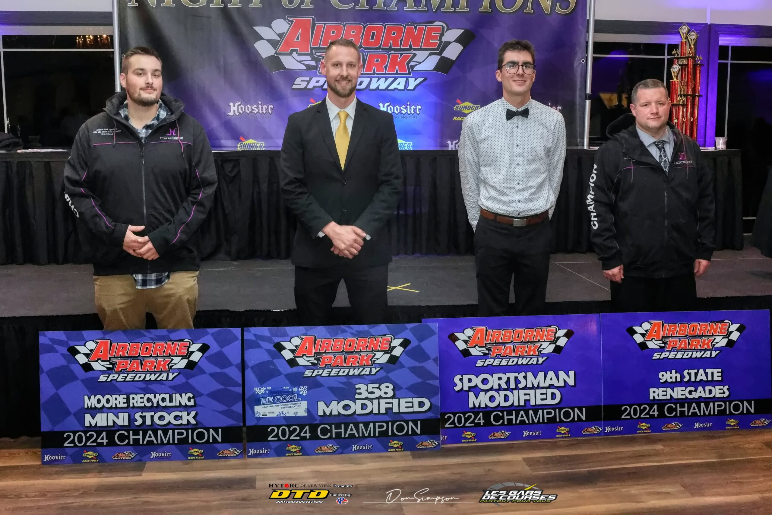 Four men holding racing banner