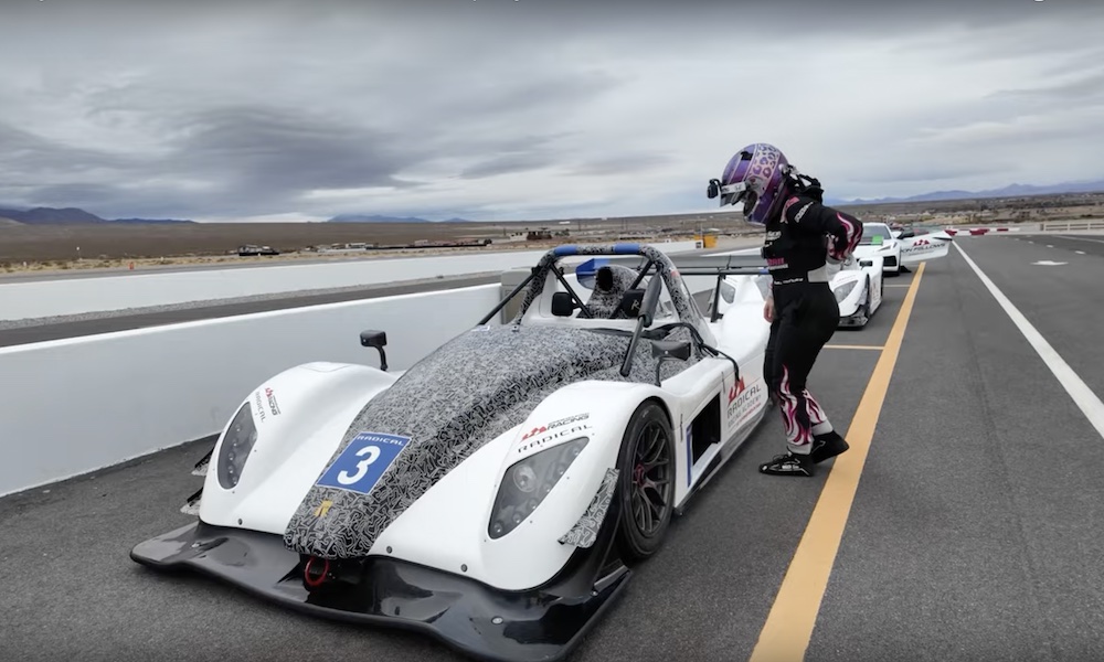 Female racer beside white racecar