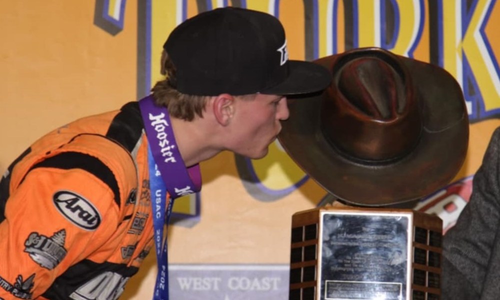 Man kisses trophy at racing event