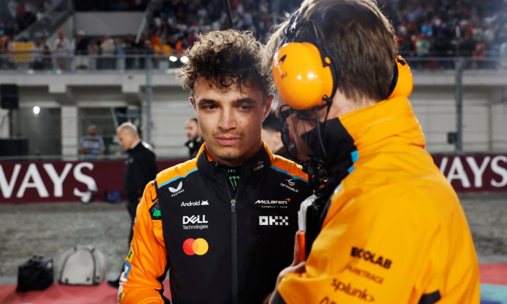 Two racers conversing in pit lane