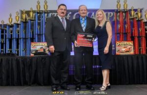 Three racers display their trophies