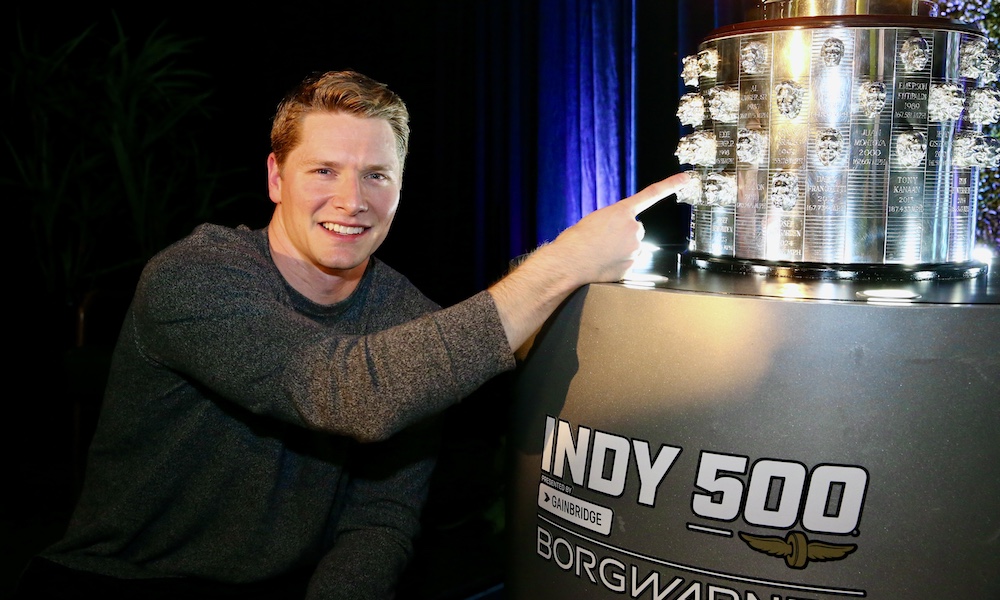 Man pointing at Indy 500 trophy