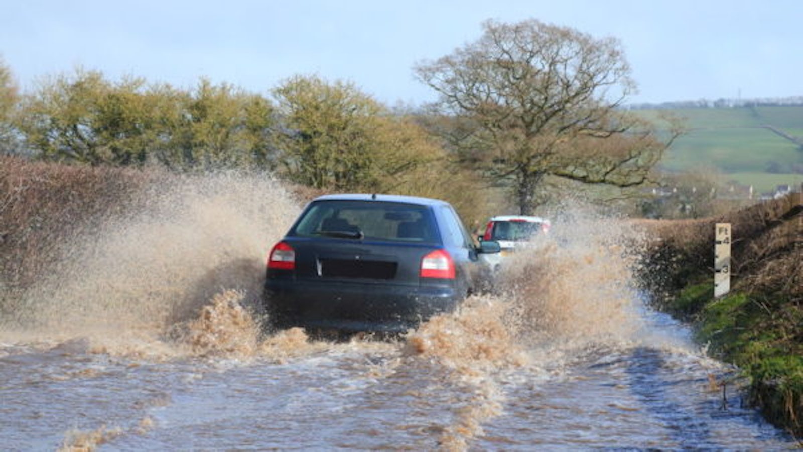 Car drives through flooded road