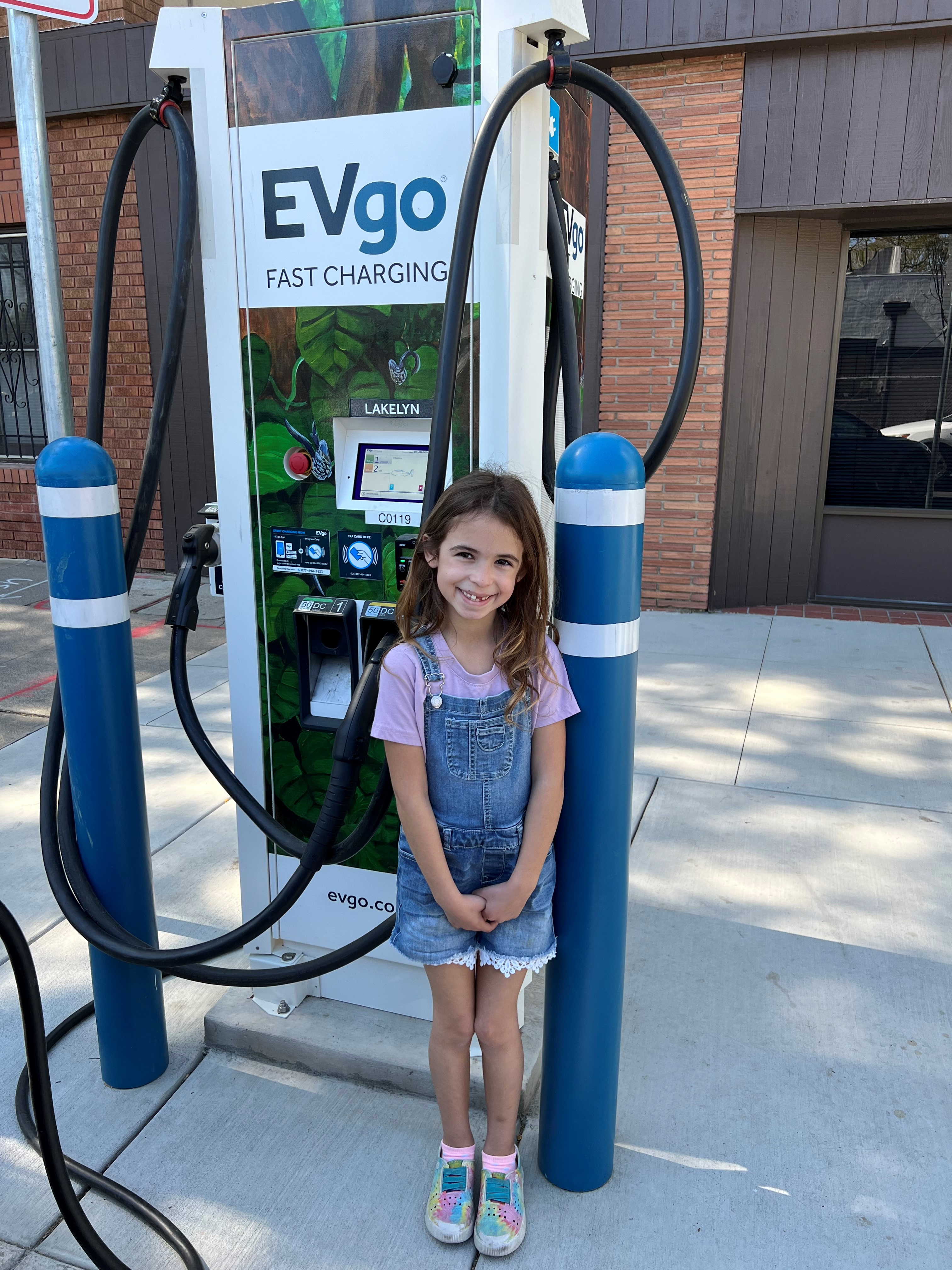 Girl smiles at EVgo charging station