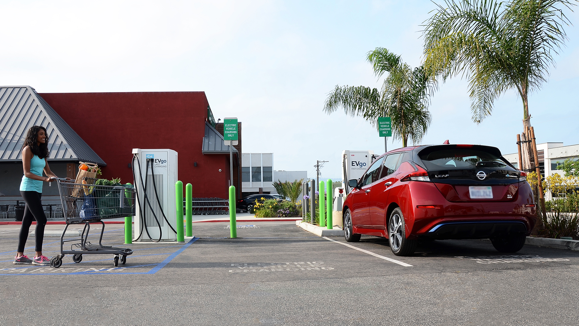 Woman charging EV while shopping