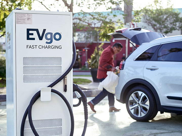 Man loading groceries while charging EV