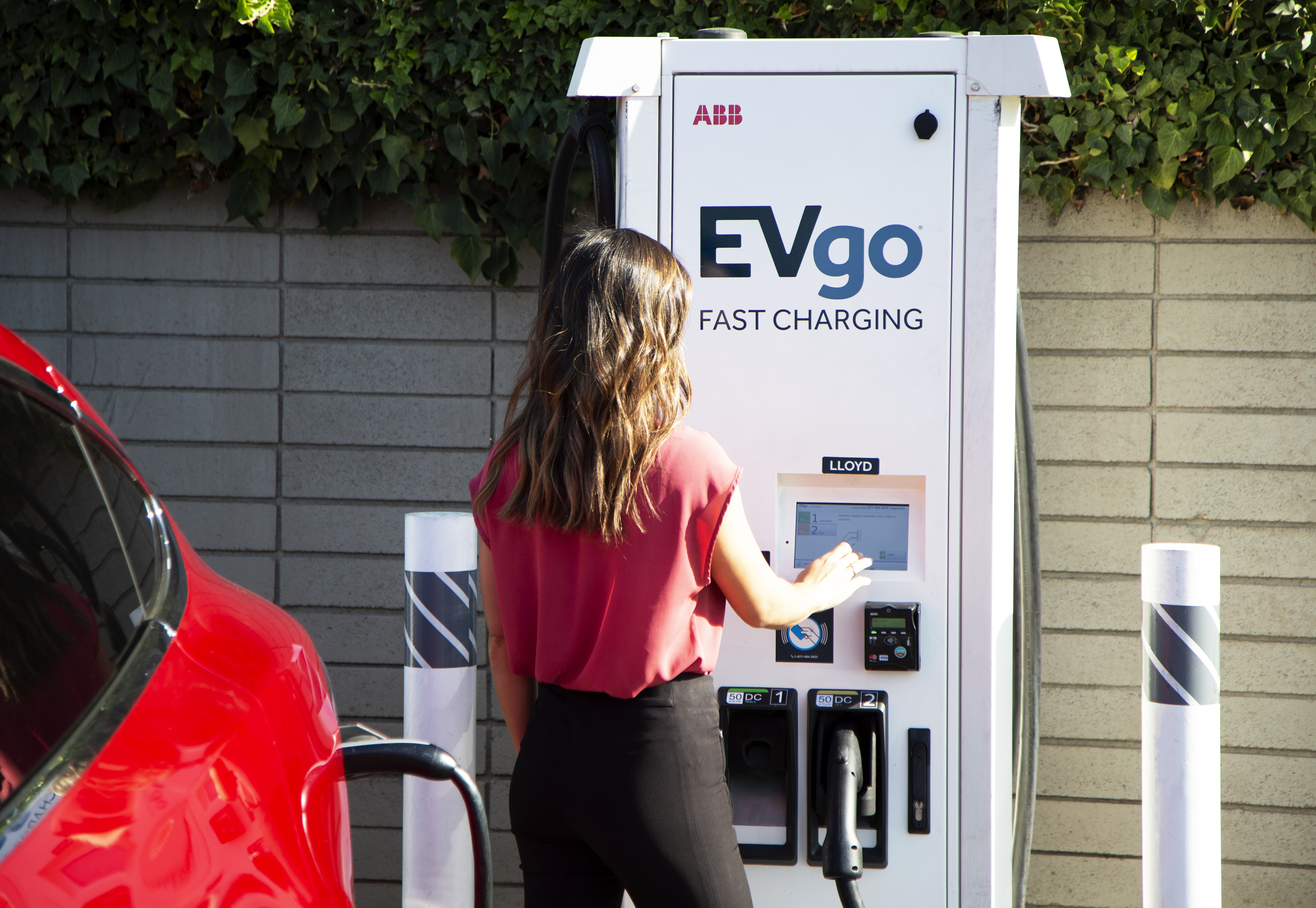 Woman charging Tesla at EVgo station