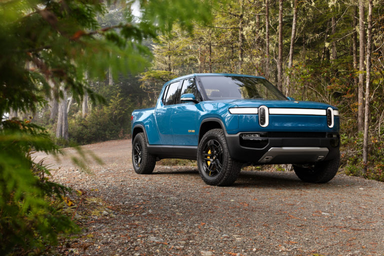 Blue Rivian R1T in forest