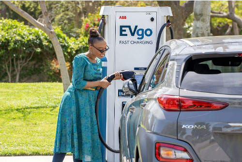 Woman charging car at EVgo station