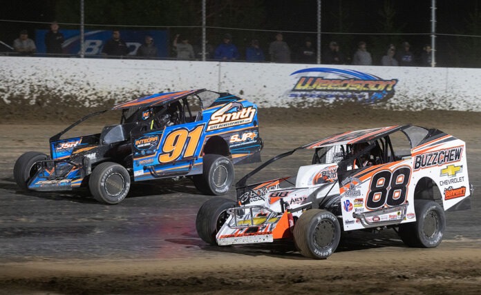 Two race cars competing in dirt track