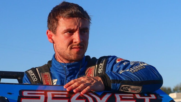 Race driver wearing blue uniform standing