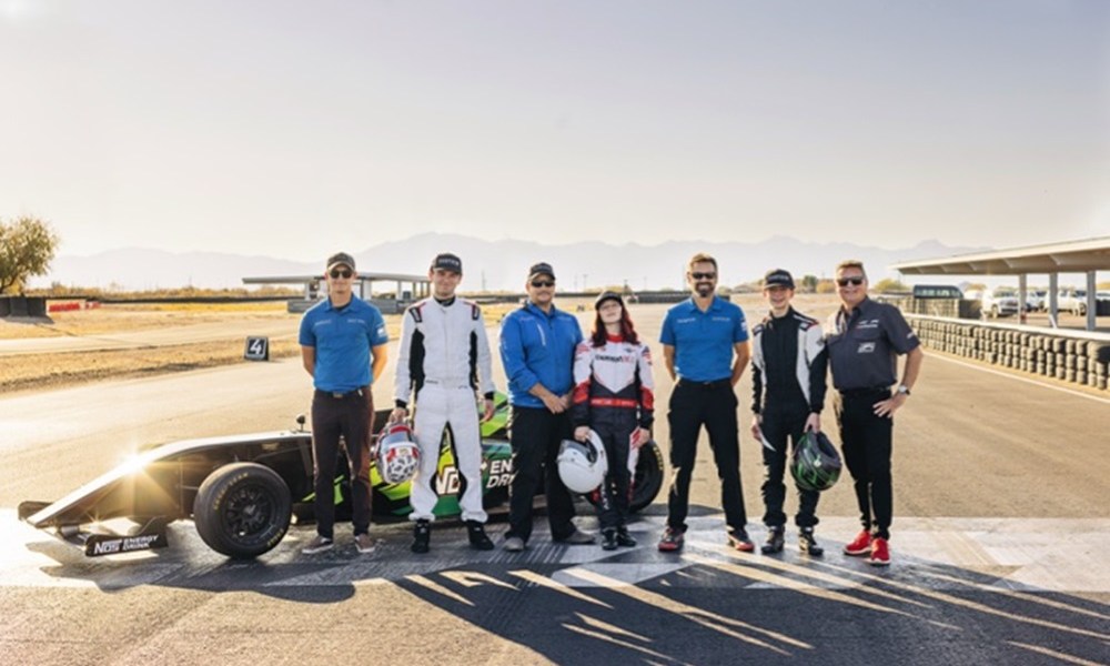 Racing team poses together outdoors