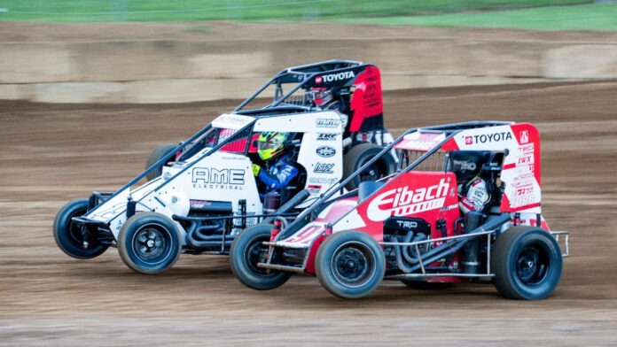 Dirt track racers battling side-by-side