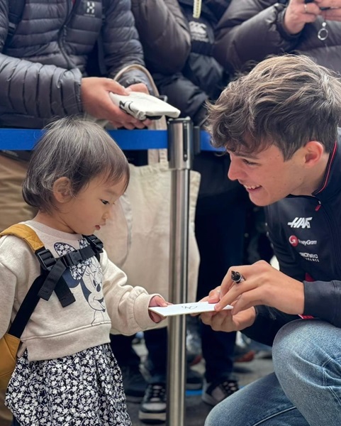 Man signing autograph for young fan