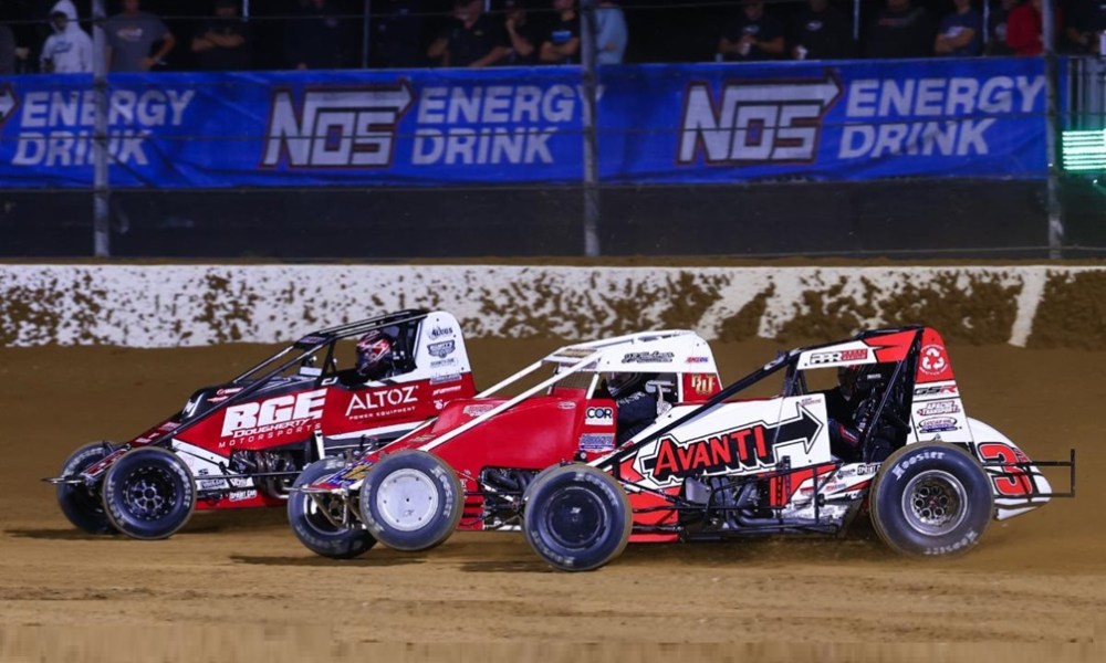 Three cars racing on dirt