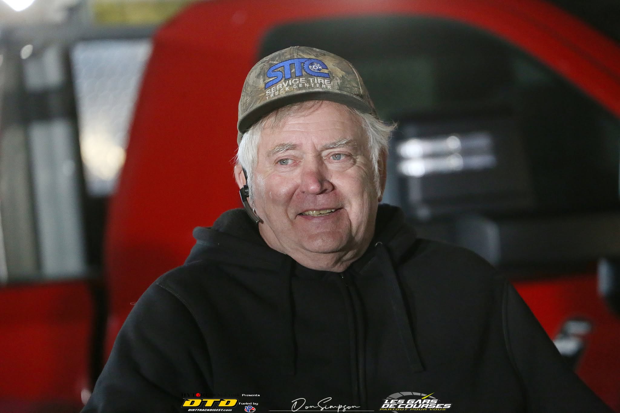 Man smiling in racing uniform