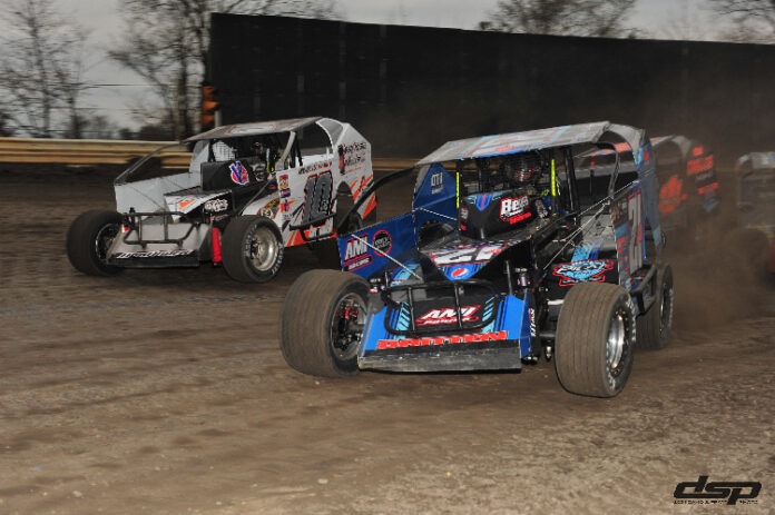 Two modifieds racing on dirt track