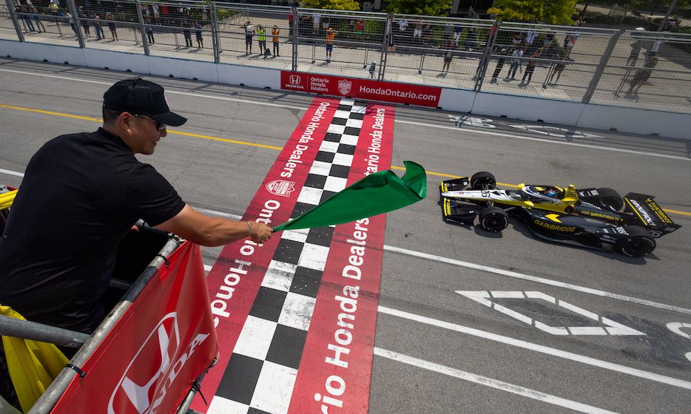 IndyCar driver waves green flag