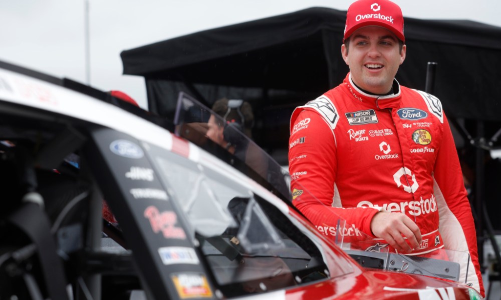 NASCAR driver beside black race car