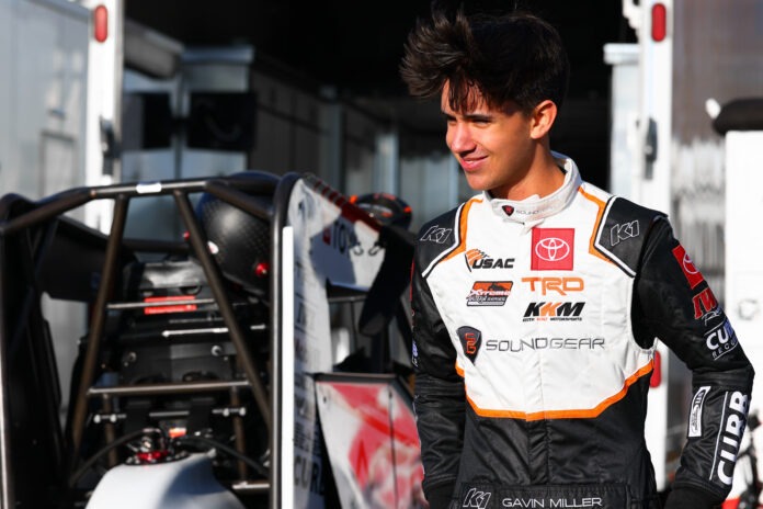 Racing driver Miller poses by car