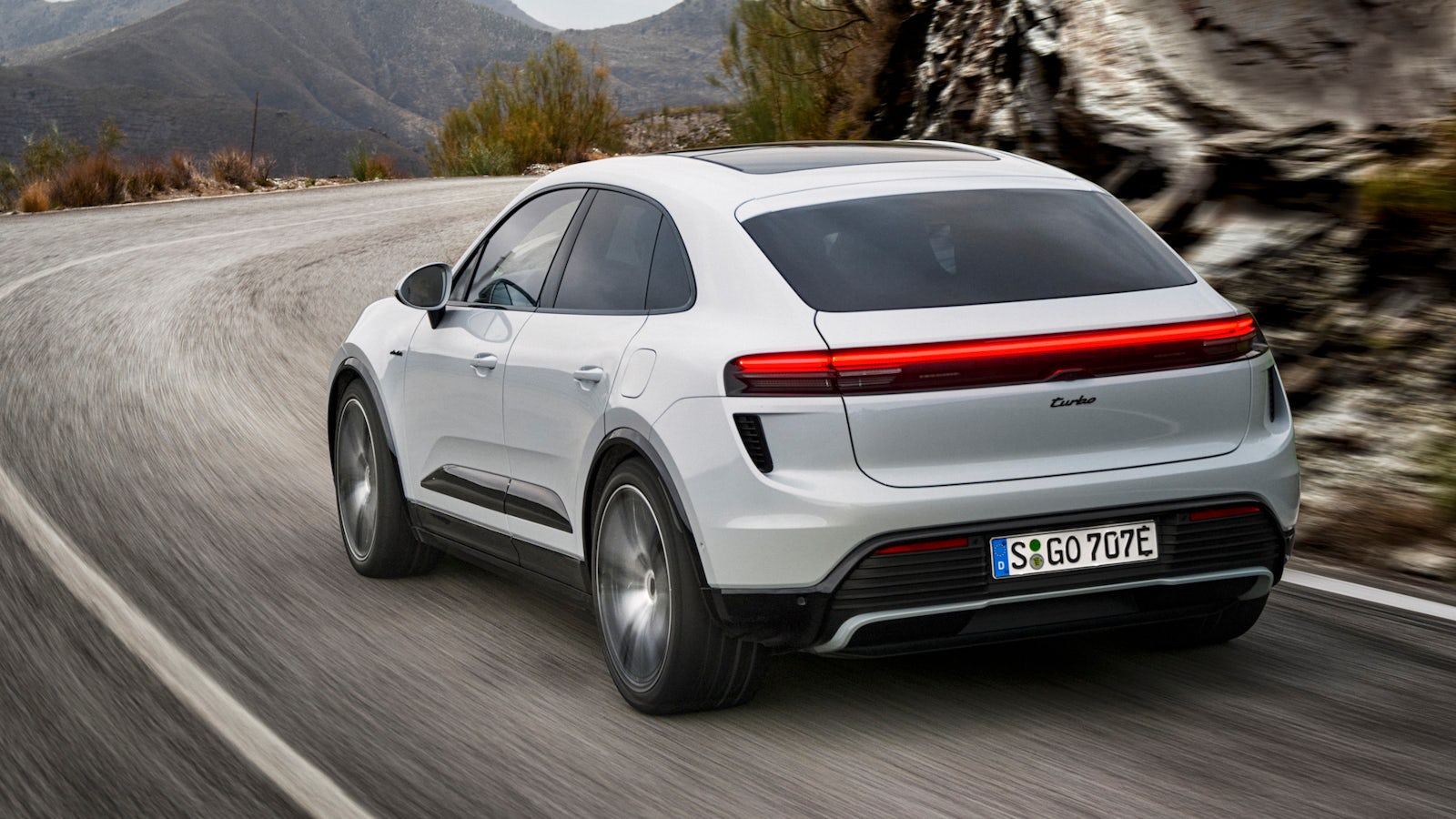 White Porsche Macan Electric driving rear-quarter