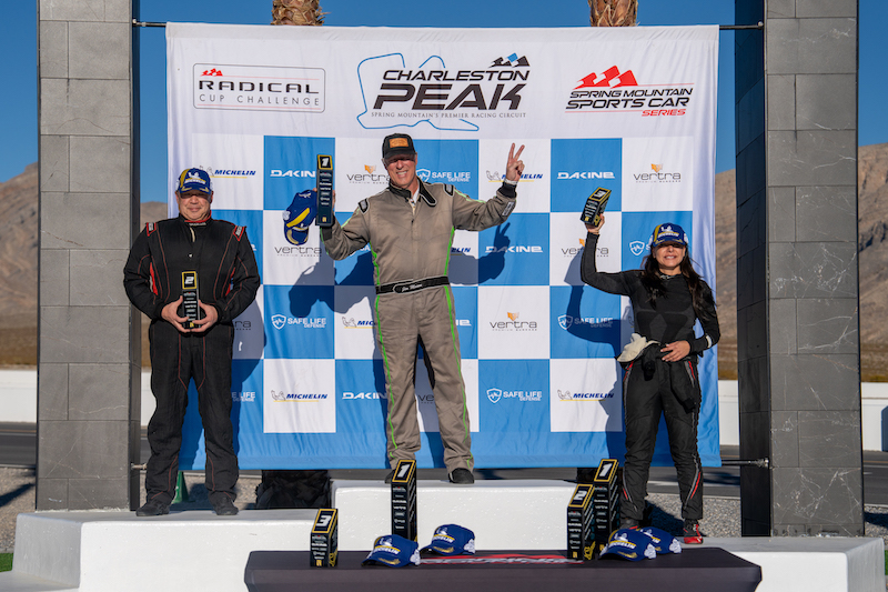 Race drivers celebrating on victory podium