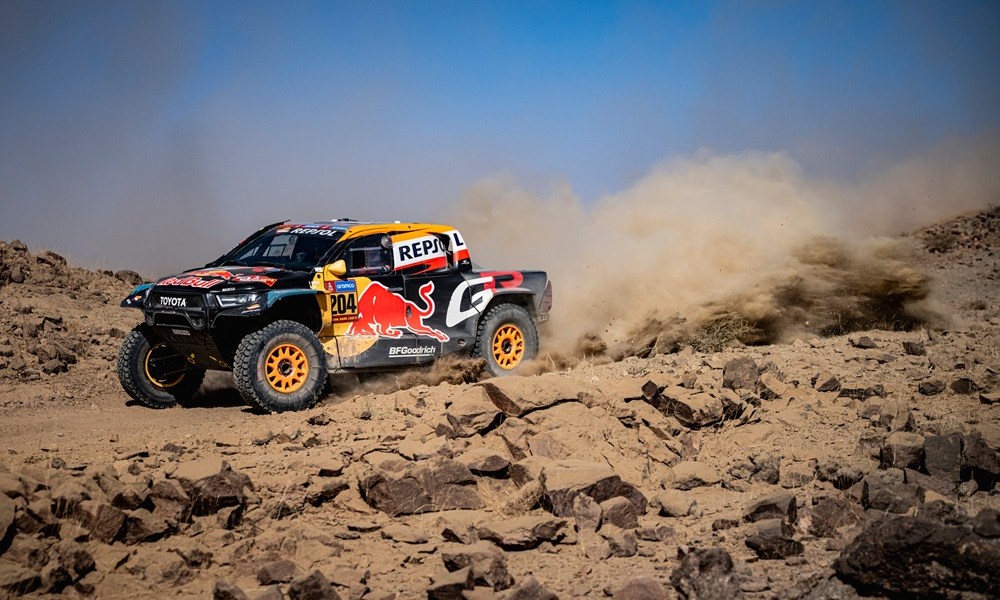 Red rally truck racing through desert