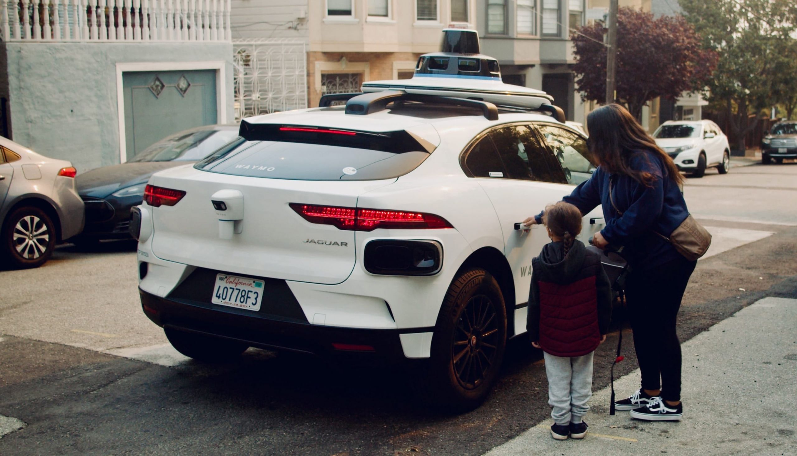 Woman and child near Waymo vehicle