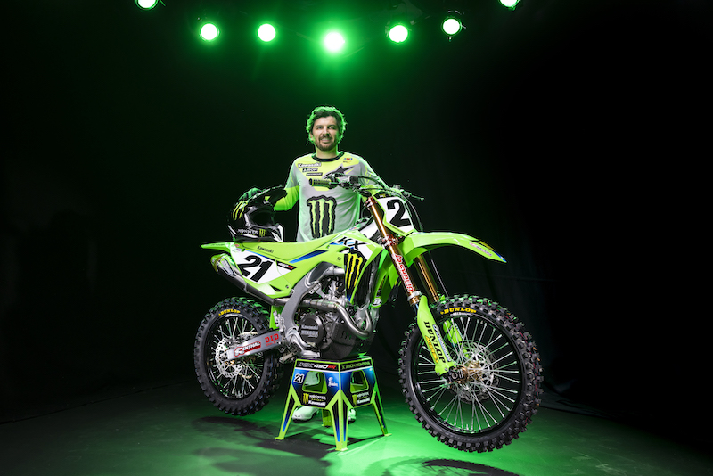 Rider poses with green Kawasaki motorcycle