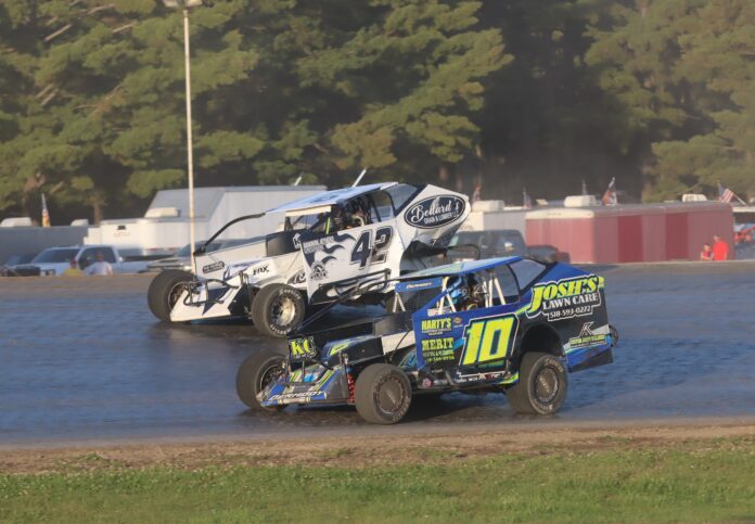 Three dirt track racers racing closely