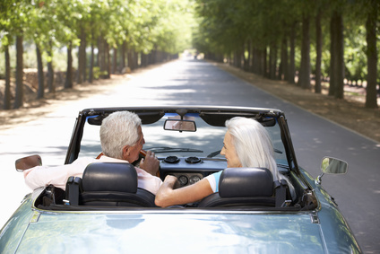 Couple driving red convertible car