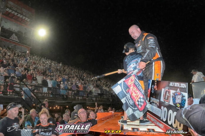 Race driver celebrating with checkered flag