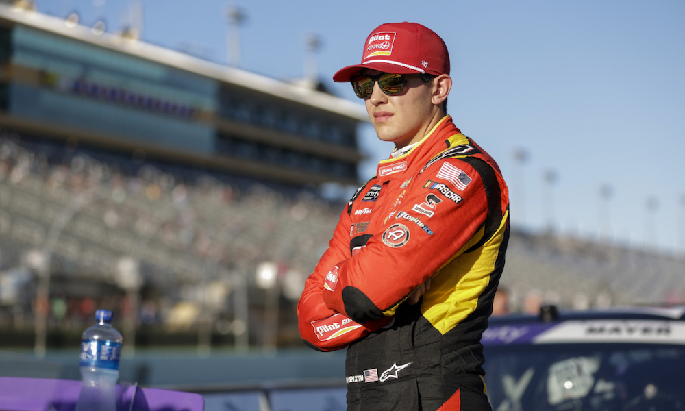 Red-yellow uniformed racing driver standing