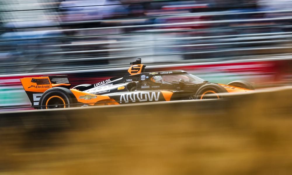 Orange McLaren IndyCar races through corner