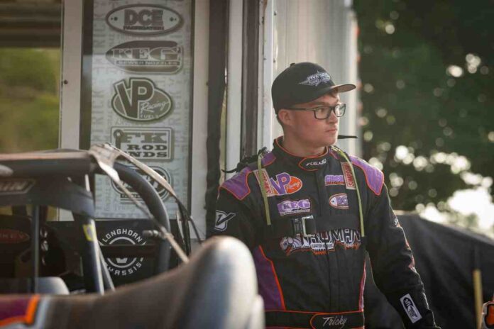 Race driver poses by dirt track