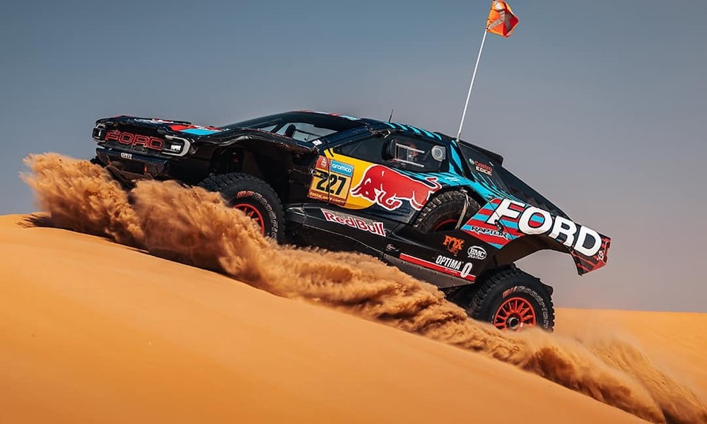 Off-road racing vehicle climbing sand dune