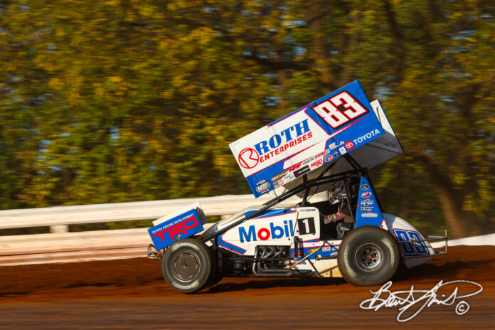 White sprint car racing on track